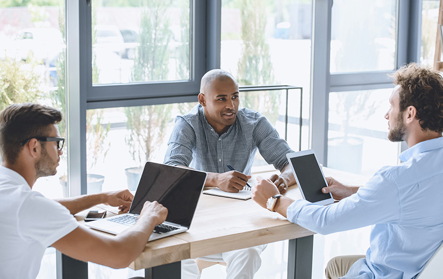 افراد در حال کار با کامپیوتر در حین جلسه